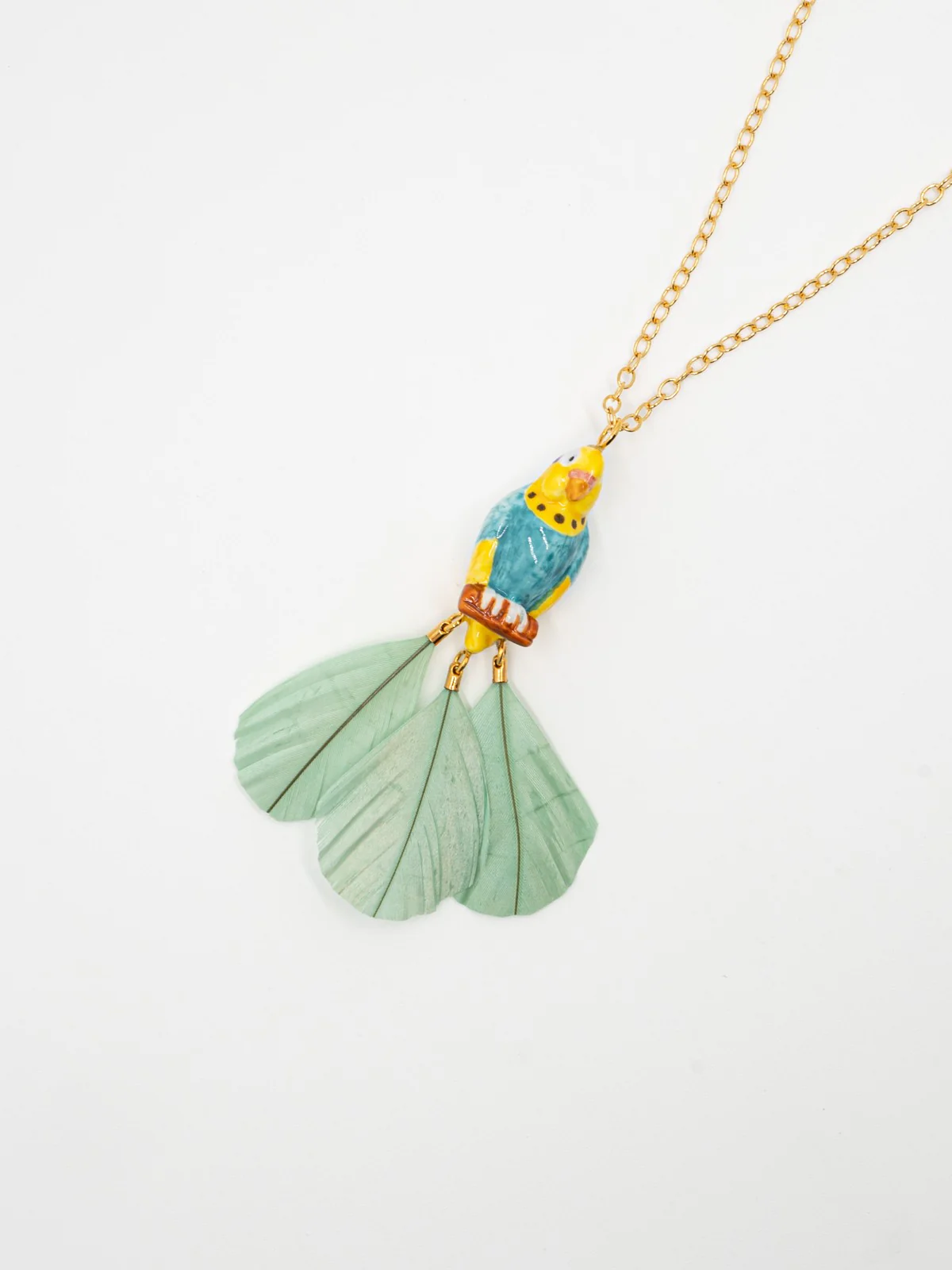 Collier perruche bleue sur branche avec plumes